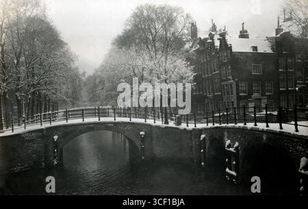 Une autre vue hivernale du Reguliersgracht, cette fois capturée depuis le pont sur le Keizersgracht, offrant une vue similaire à la photo précédente, prise en 1916. Banque D'Images