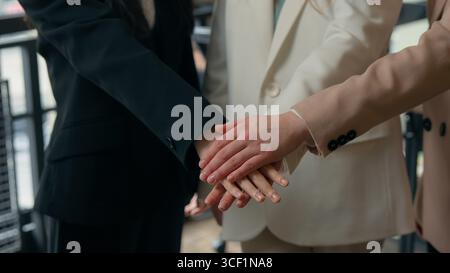 Trois femmes d'affaires méconnaissables succès travail d'équipe dans le bureau empilant les mains multiraciales collègues multiethniques femmes d'affaires filles femmes Banque D'Images