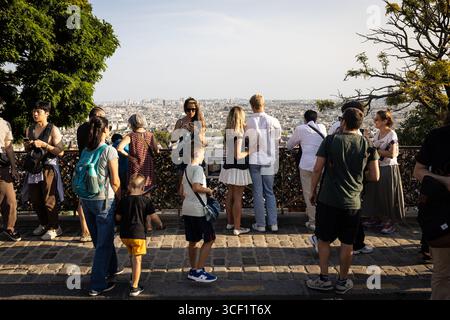 Les touristes apprécient la vue depuis le point de vue au sommet de la colline en face de la basilique du Sacré-Cœur à Montmartre. La vie quotidienne dans le quartier de Montmartre, dans le 18ème arrondissement de Paris, célèbre pour sa Basilique du Sacré-cœur au sommet de la colline avec une magnifique vue panoramique sur Paris, ce qui en fait l’un des quartiers les plus touristiques de la ville. Banque D'Images
