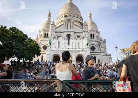 Les touristes apprécient la vue depuis le point de vue au sommet de la colline en face de la basilique du Sacré-Cœur à Montmartre. La vie quotidienne dans le quartier de Montmartre, dans le 18ème arrondissement de Paris, célèbre pour sa Basilique du Sacré-cœur au sommet de la colline avec une magnifique vue panoramique sur Paris, ce qui en fait l’un des quartiers les plus touristiques de la ville. Banque D'Images