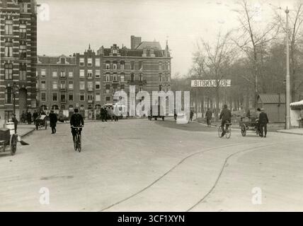 Des travaux de pavage d'asphalte sont effectués à Amsterdam en 1923. Un panneau au-dessus de la rue indique « Bitumenweg », indiquant que la route est pavée de bitume. Banque D'Images