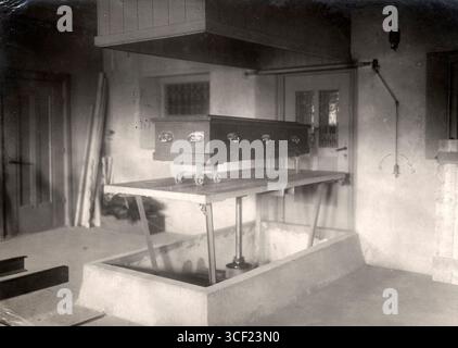 Au crématorium de Westerveld à Driehuis, aux pays-Bas, en 1921, un cercueil est descendu dans la chambre de crémation lors d'un service funéraire. Banque D'Images