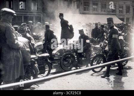 Le début d'une course de moto pour les soldats néerlandais vers 1930. L'image capture des militaires qui se préparent à participer à une compétition de course, mettant en valeur leurs véhicules et uniformes de l'époque. Banque D'Images
