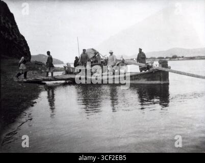 Un participant à la course de Pékin à Paris en 1907 est transporté sur une rivière en Mongolie, mettant en valeur l'endurance et l'aventure longue distance de cette course automobile historique. Banque D'Images