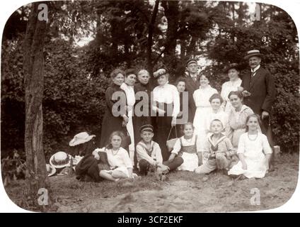 Ce portrait de groupe, pris dans une forêt le 1er août 1916, représente des hommes, des femmes et des enfants habillés en tenue de marin dans un lieu inconnu aux pays-Bas. Banque D'Images