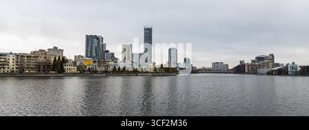 Vue panoramique des gratte-ciel et des maisons modernes et anciennes dans la rivière Iset Iekaterinburgi au premier plan Ekaterinbourg, Russie Banque D'Images