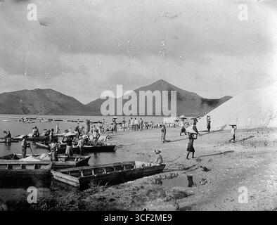 Négatif en verre de 1930-1950 représentant des ouvriers qui ramassent du sel à Philipsburg, Saint-Martin, une activité clé de production de sel dans les Caraïbes au cours du XXe siècle. Banque D'Images