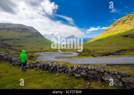 Vue d'une route sinueuse menant à l'île de Koltur en arrière-plan. Streymoy, Torshavnar district, Îles Féroé, Danemark, Scandinavie. Banque D'Images