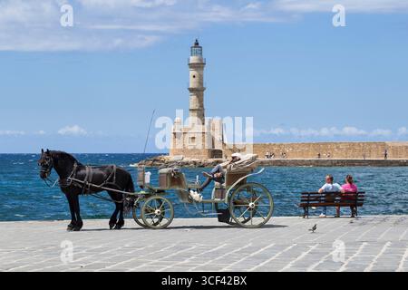 Calèche tirée par des chevaux au vieux port vénitien de la Canée, phare en arrière-plan, Crète, Grèce, Europe Banque D'Images