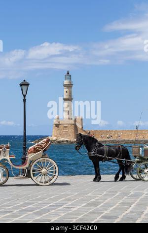 Calèche tirée par des chevaux au vieux port vénitien de la Canée, phare en arrière-plan, Crète, Grèce, Europe Banque D'Images
