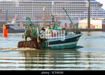 Le Havre, France - 16 janvier 2025 : chalutier quittant les quais du Havre pour pêcher dans la Manche. En arrière-plan se trouve un bateau de croisière. Banque D'Images