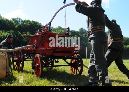 Pompiers utilisant une pompe à main historique pendant la compétition à Rudawka Rymanowska, Podkarpackie, Pologne Banque D'Images