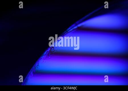 Film fluide violet, fond fluide, ondes plates, mouvement lisse, espace de copie sombre, abstraction d'encre violette Banque D'Images