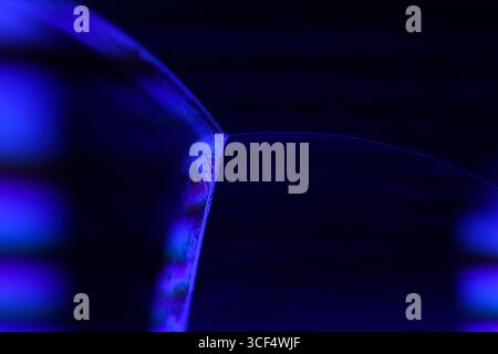 Film fluide violet, fond fluide, ondes plates, mouvement lisse, espace de copie sombre, abstraction d'encre violette Banque D'Images