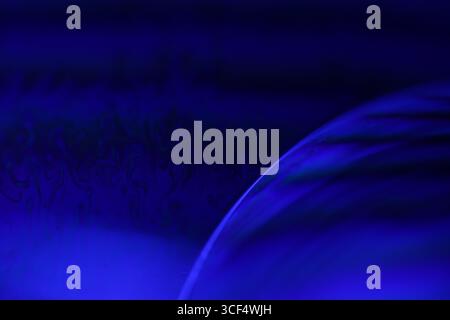 Film fluide violet, fond fluide, ondes plates, mouvement lisse, espace de copie sombre, abstraction d'encre violette Banque D'Images