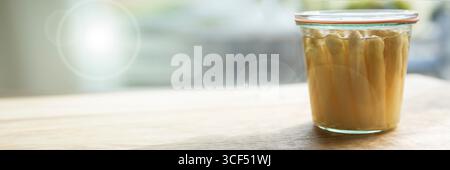 Asperges blanches fraîchement conservées dans un pot mason. Nourriture horizontale-fotografie avec bokeh ensoleillé pour une alimentation saine. Arrière-plan avec espace pour le texte. Banque D'Images