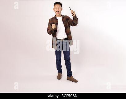 homme excité exprimant la joie avec une pose joyeuse sur un fond clair Banque D'Images
