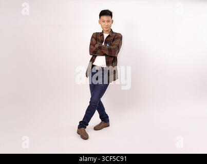 Portrait décontracté d'un jeune homme debout avec confiance dans une chemise à carreaux et un Jean Banque D'Images