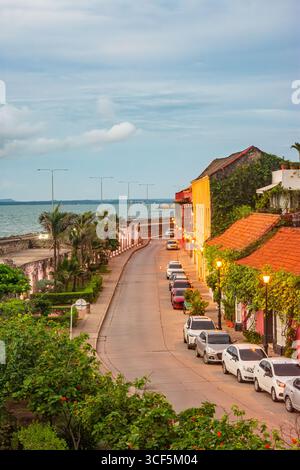 Charmante rue dans le centre historique de Carthagène, Colombie, avec des bâtiments colorés, des palmiers et des vues panoramiques sur l'océan. Banque D'Images