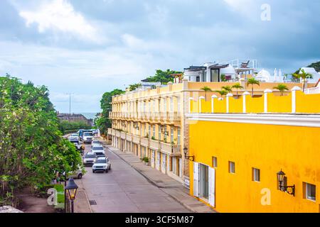 Vue panoramique sur une rue animée dans le centre historique de Carthagène, Colombie, avec des bâtiments colorés et de la verdure. Banque D'Images
