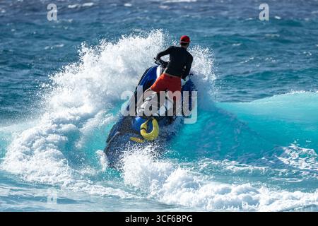 Dramatique et intense sauveteur de jet ski de sauvetage océanique perçant à travers la haute mer, naviguant puissant surf avec précision, mission solo urgente Banque D'Images