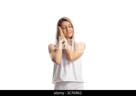 Jeune femme en pyjama dormant isolé sur fond blanc Banque D'Images