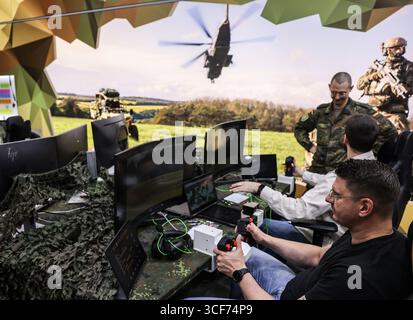 Cologne, Allemagne. 21 août 2025. Les visiteurs de la Gamescom sont assis devant des jeux de simulation sur ordinateur au stand de la Bundeswehr. L'armée allemande recrute de nouvelles recrues au salon des jeux vidéo de la Gamescom. Crédit : Oliver Berg/dpa/Alamy Live News Banque D'Images