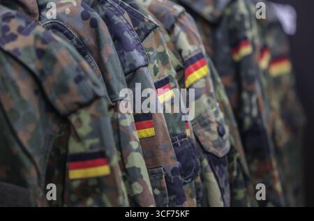 Cologne, Allemagne. 21 août 2025. Vestes de terrain suspendues sur le stand de la Bundeswehr. L'armée allemande est à la recherche de nouvelles recrues au salon des jeux vidéo de la Gamescom. Crédit : Oliver Berg/dpa/Alamy Live News Banque D'Images