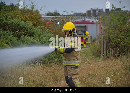 Pompiers face à un incendie gorse à Amlwch. Banque D'Images