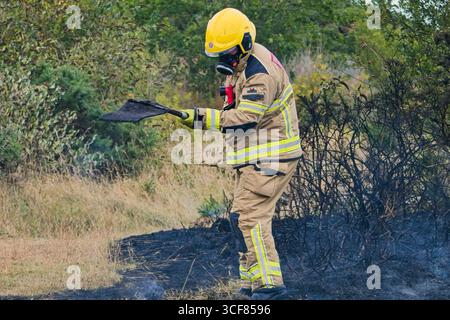Pompiers face à un incendie gorse à Amlwch. Banque D'Images
