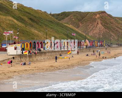 Une rangée de cabanes de plage traditionnelles aux couleurs vives sur la promenade de la station balnéaire populaire de Saltburn-by-the-Sea, North Yorkshire, Royaume-Uni. Banque D'Images