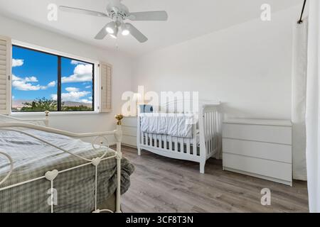 Cette chambre spacieuse et bien éclairée dispose d''un design confortable avec un lit bébé, un mobilier moderne et une vue panoramique. Parfait pour les environnements familiaux ou adaptés aux enfants Banque D'Images