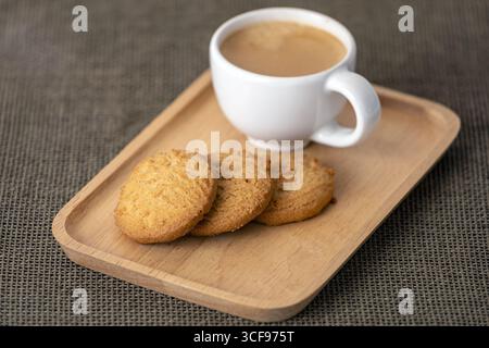 Un café espresso shot avec des biscuits sur un plateau en bois, boisson chaude, collation sucrée, atmosphère chaleureuse, rafraîchissement du matin, style rustique, ambiance invitante Banque D'Images