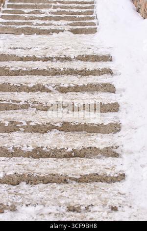 Marches en béton recouvertes de neige avec léger dépoussiérage de neige et de glace en hiver. Banque D'Images