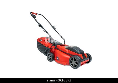 Tondeuse à gazon rouge et noire, vue latérale inclinée. Périphérique isolé sur fond blanc. Banque D'Images