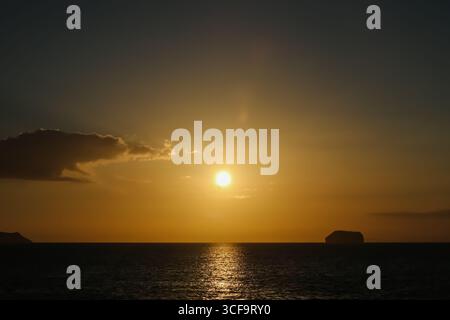 Vue sur les îles Daphné au coucher du soleil depuis la proue du bateau de croisière Celebrity Xpedition, îles Galápagos, Équateur. Banque D'Images