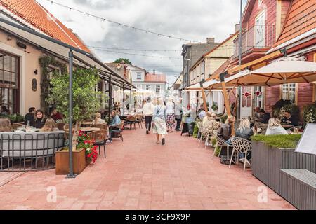 Rue animée dans la vieille ville de Parnu, avec des gens marchant le long d'un chemin pavé, cafés en plein air, restaurants, boutiques et vieilles maisons Banque D'Images