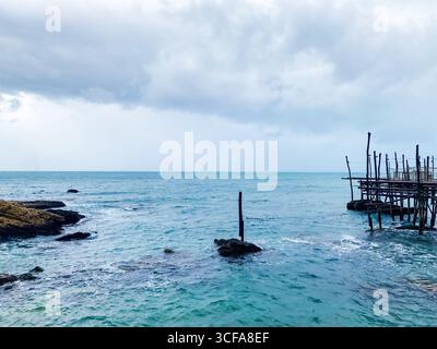 Plate-forme de pêche en bois trabocco debout sur la côte rocheuse près de Rocca San Giovanni, Abruzzes, avec ciel couvert au-dessus du paysage maritime traditionnel Banque D'Images