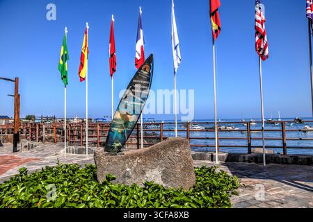 Île de San Cristóbal, Îles Galápagos, Équateur : 29 mars 2018 : monument de bienvenue et drapeaux internationaux le long du front de mer sur San Cristobal Banque D'Images