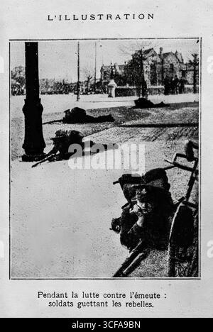 Photographie tirée de L’illustration (1916) montrant des soldats britanniques couchés sur le ventre pendant le soulèvement de Pâques à Dublin. Les soldats sont vus se mettre à couvert derrière des traits de rue, surveillant les insurgés. Cette image illustre la guerre urbaine de la rébellion, où des volontaires irlandais et des combattants de l'Armée citoyenne ont affronté les forces britanniques lourdement armées dans les rues de la ville, marquant l'un des moments marquants de l'histoire moderne de l'Irlande. Banque D'Images