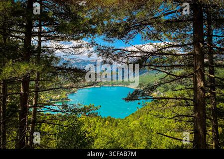 Branches de pin encadrant une vue imprenable sur le lac Scanno, un lac turquoise en forme de cœur niché dans les Apennins des Abruzzes, en Italie, créant un pittoresque Banque D'Images