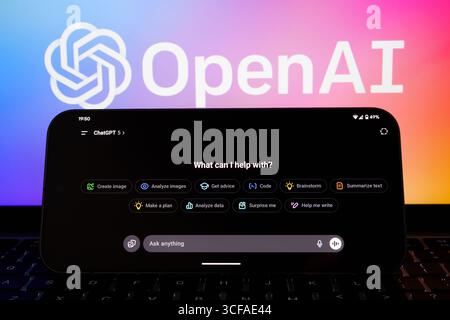 Interface ChatGPT 5 en paysage sur smartphone avec clavier d'ordinateur portable et fond de logo OpenAI dégradé. Stafford, Royaume-Uni, 21 août 2025 Banque D'Images