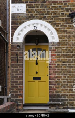 Porte jaune avec White Arch dans la façade de brique de la Maison historique. Redhill, Angleterre Banque D'Images