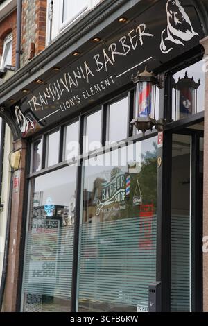 Extérieur élégant du salon de coiffure avec logo et poteaux de coiffure. Redhill, Angleterre Banque D'Images