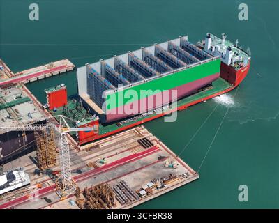 YANTAI, CHINE - 21 AOÛT 2025 - les navires semi-submersibles se préparent à transporter de grandes coques de porte-conteneurs par sections jusqu'à la base d'assemblage final du chantier naval Hanwha Marine Shipyard dans la ville de Yantai, province du Shandong, Chine, le 21 août 2025. Banque D'Images