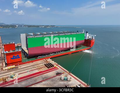 YANTAI, CHINE - 21 AOÛT 2025 - les navires semi-submersibles se préparent à transporter de grandes coques de porte-conteneurs par sections jusqu'à la base d'assemblage final du chantier naval Hanwha Marine Shipyard dans la ville de Yantai, province du Shandong, Chine, le 21 août 2025. Banque D'Images