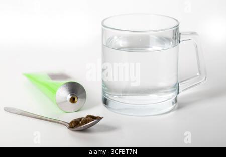Pâte urologique sur les herbes sur le fond d'un verre d'eau. Traitement des maladies inflammatoires infectieuses de l'appareil urinaire Banque D'Images