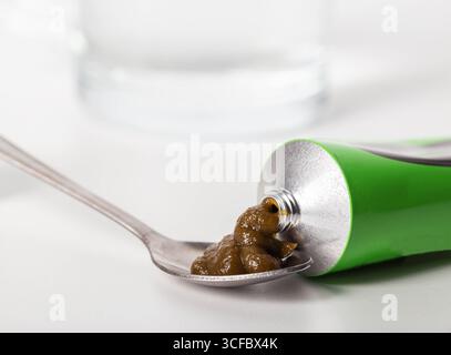 Pâte urologique sur les herbes sur le fond d'un verre d'eau. Traitement des maladies inflammatoires infectieuses de l'appareil urinaire Banque D'Images