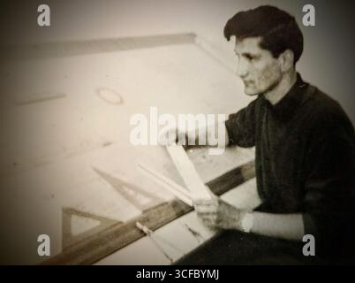 Vieille photo floue en noir et blanc d'un dessinateur à un bureau de rédaction - Novi Sad, Serbie, Yougoslavie des années 1960 Banque D'Images