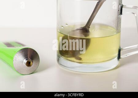 Pâte urologique sur les herbes sur le fond d'un verre d'eau. Traitement des maladies inflammatoires infectieuses de l'appareil urinaire Banque D'Images